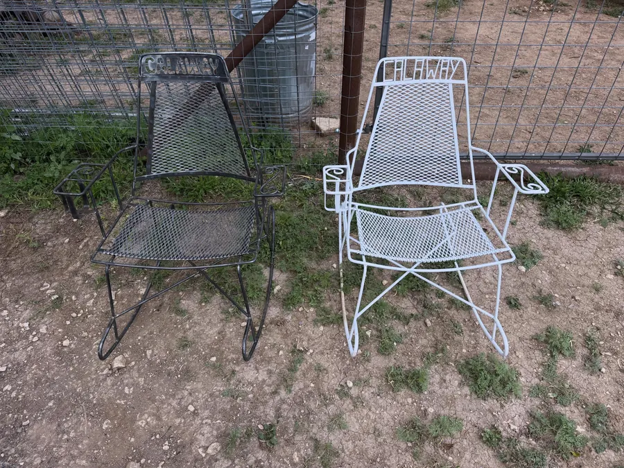 A pair of wire-mesh patio rockers before paint, one old and one newly welded up to match it, sitting on the grass