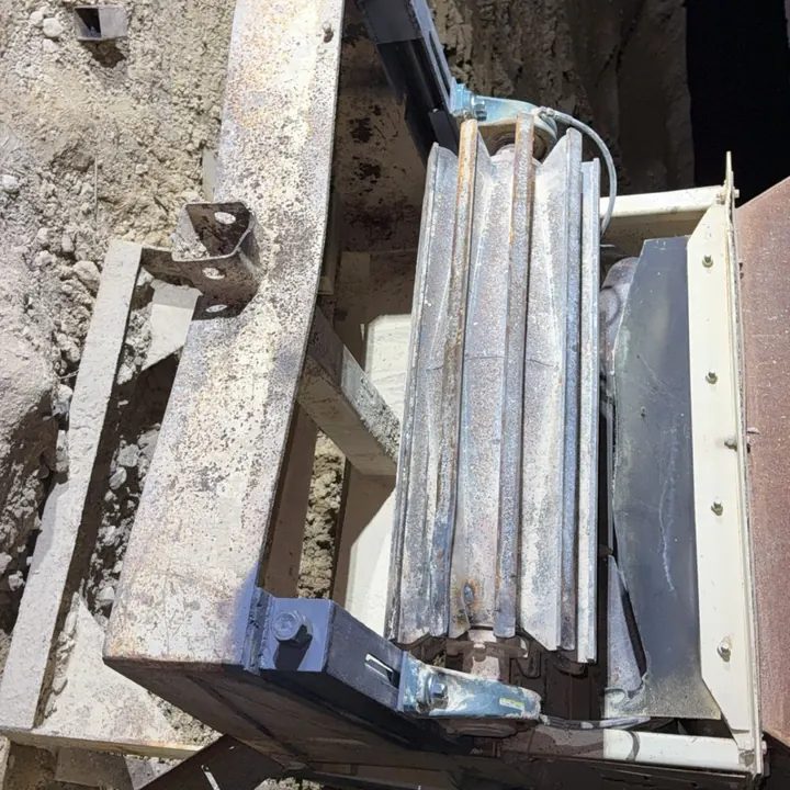 An old stacker frame opened up to show a redesigned steel belt tensioner welded in place